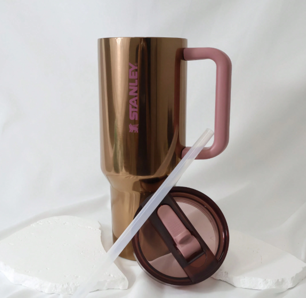 Stanley 40oz bronze travel tumbler with straw and pink handle